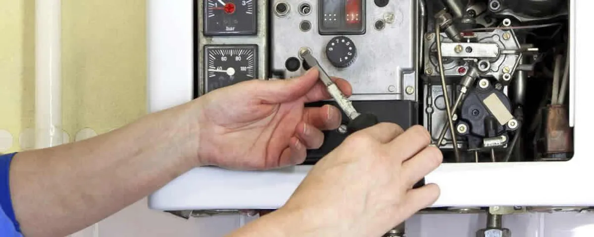 Heating repair technician adjusting boiler controls and components in Wellesley, MA