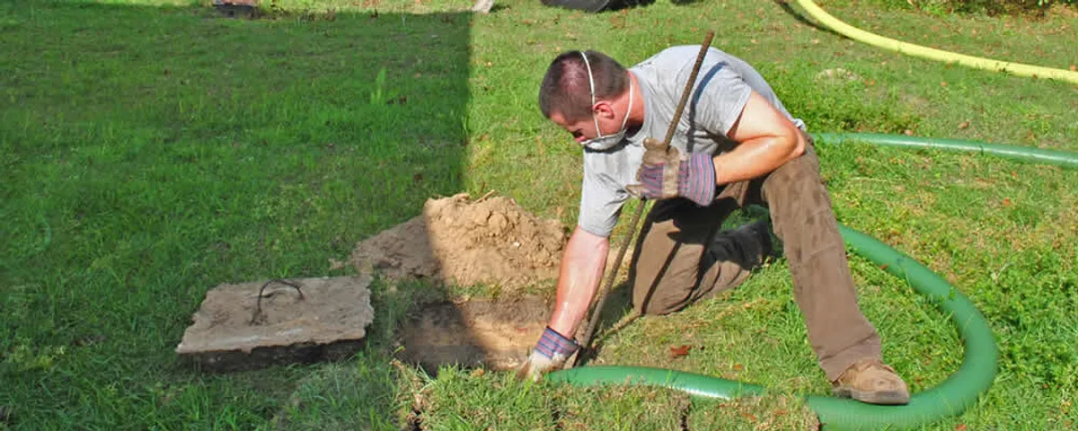 Septic pumping technician servicing a residential septic tank in Wellesley, MA