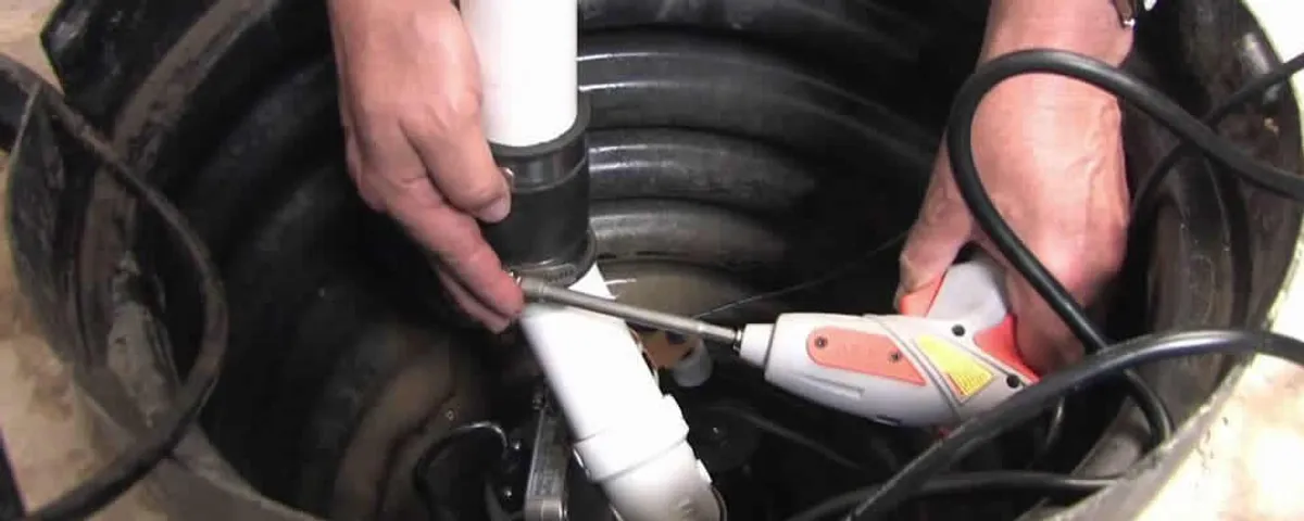 Sump pump installation technician connecting PVC discharge piping in Wellesley, MA