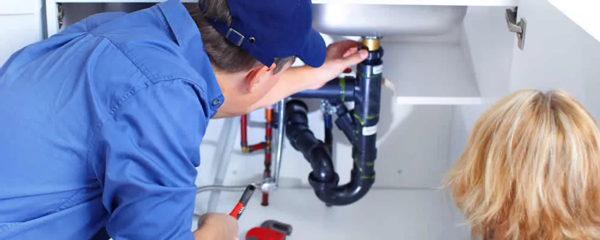 Plumber repairing under-sink drain pipes and fittings in Wellesley, MA